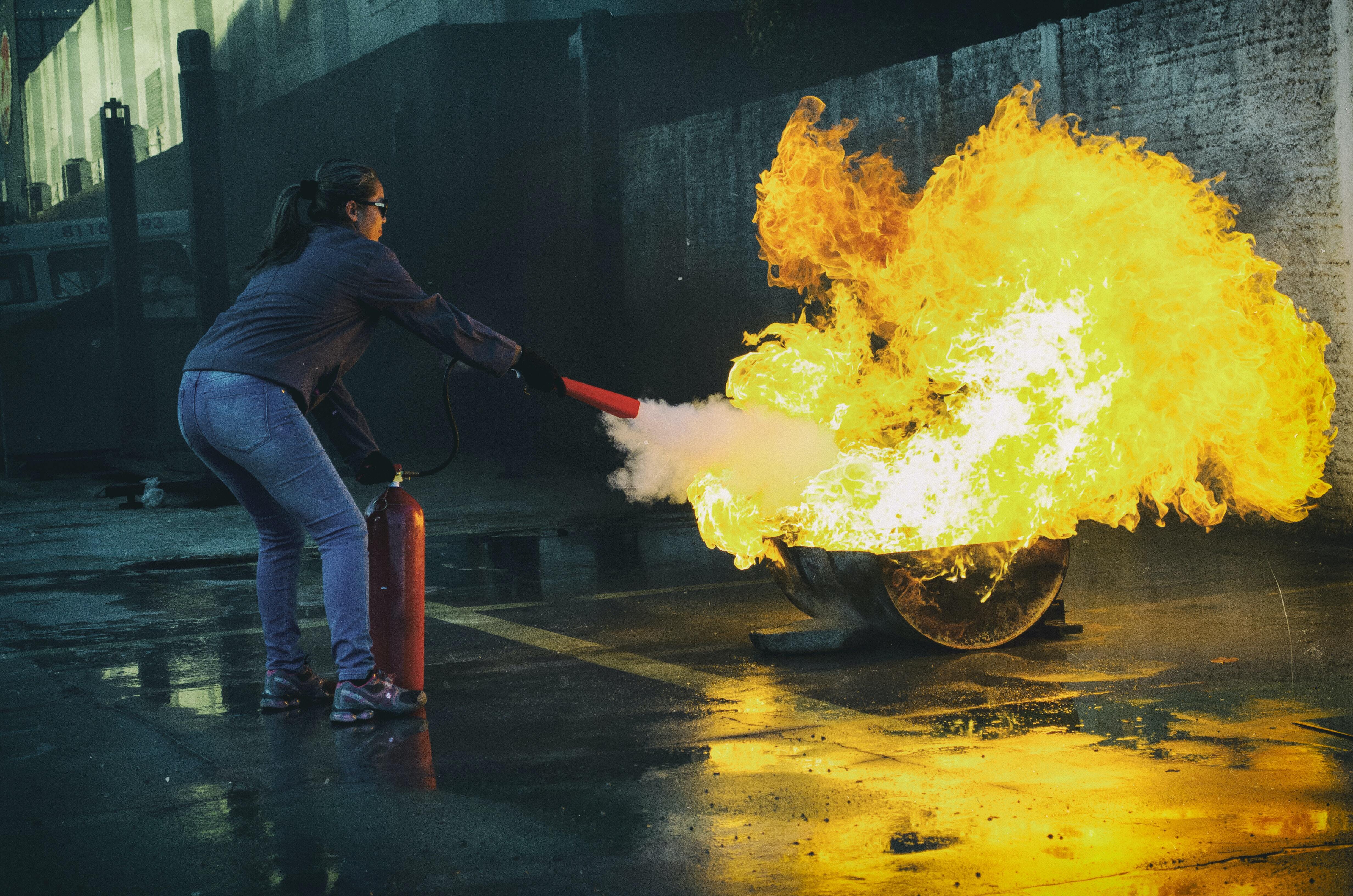 fire extinguisher demonstration woman extinguishes fire live in a demonstration metal pan