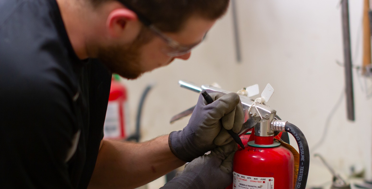 Technician labeling extinguisher during inspection