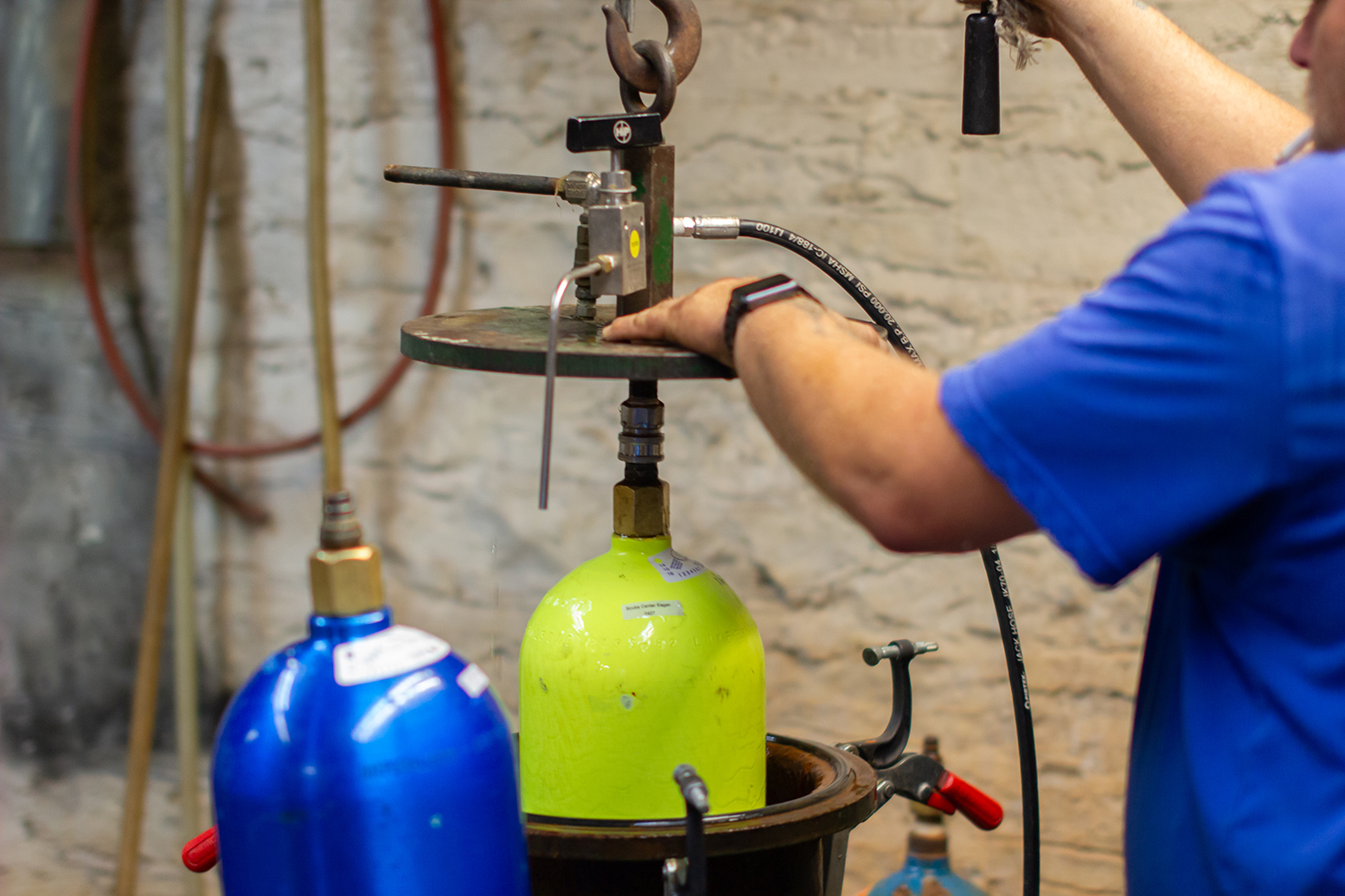 Technician high pressure hydrostatic testing a SCUBA tank on site